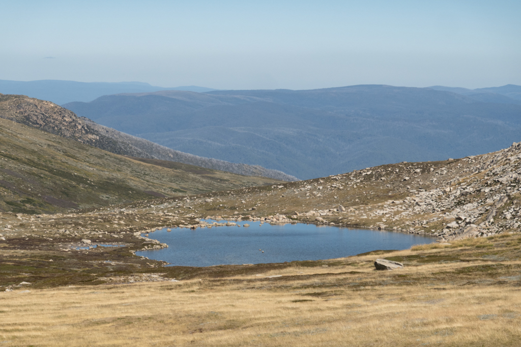 Ein kleiner flacher Bergsee am Wanderweg