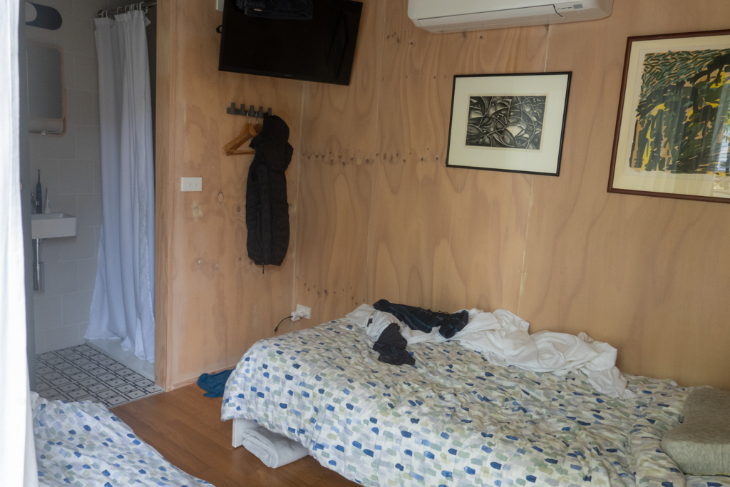Innenansicht des 10qm kleinen Ateliers. 1 Bett und eine Matratze am Boden. Hinten Dusche und WC...