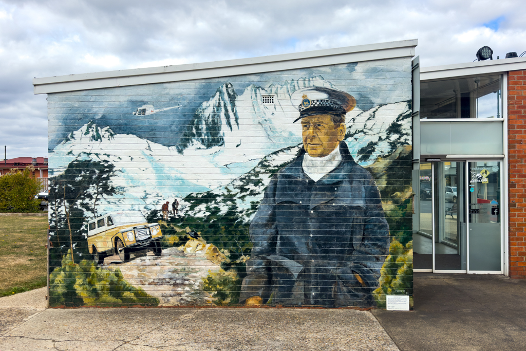 Ein Wandbild der verschneiten Cradle Mountains mit einem Rettungsheli...
