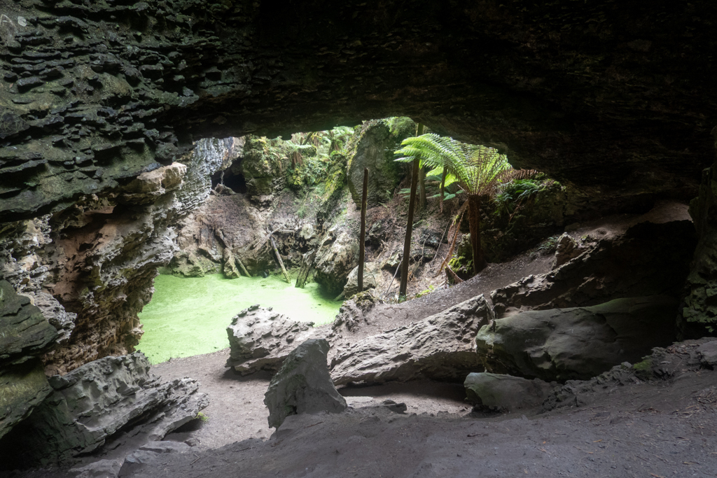 Der Trowutta Arch, dahinter ein kleiner Tümpel mit Algen und üppige Vegetation