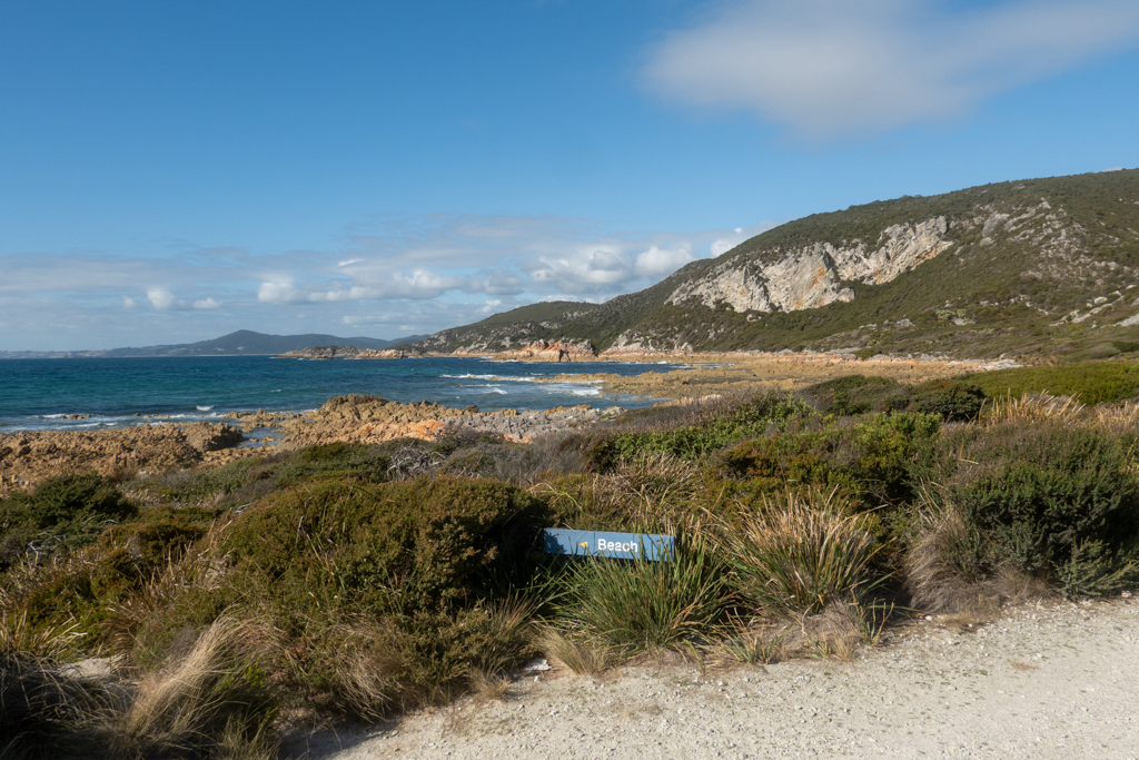 Blick auf die rötlichen Felsen der Bucht bei der South Cave im Rocky Cave N.P.