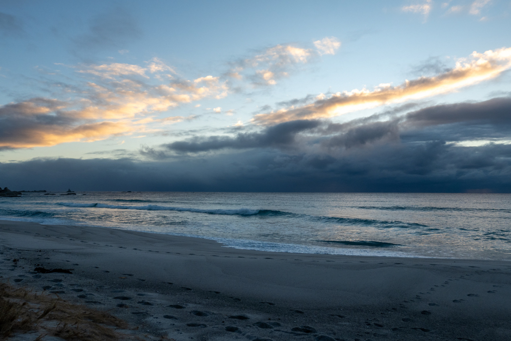 Noch ist es dunkel am Morgen; die Sonne versteckt sich noch hinter den dichten Wolken am Horizont