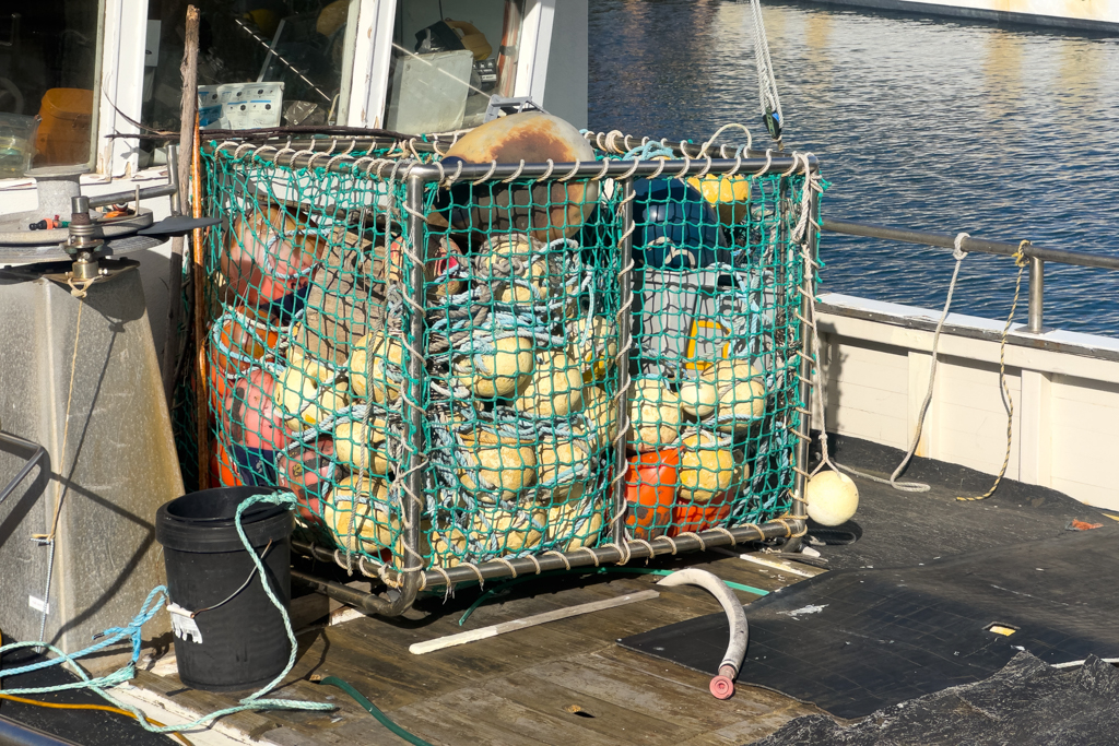 Eine Box voller Netzbojen an Bord eines kleinen Kutters
