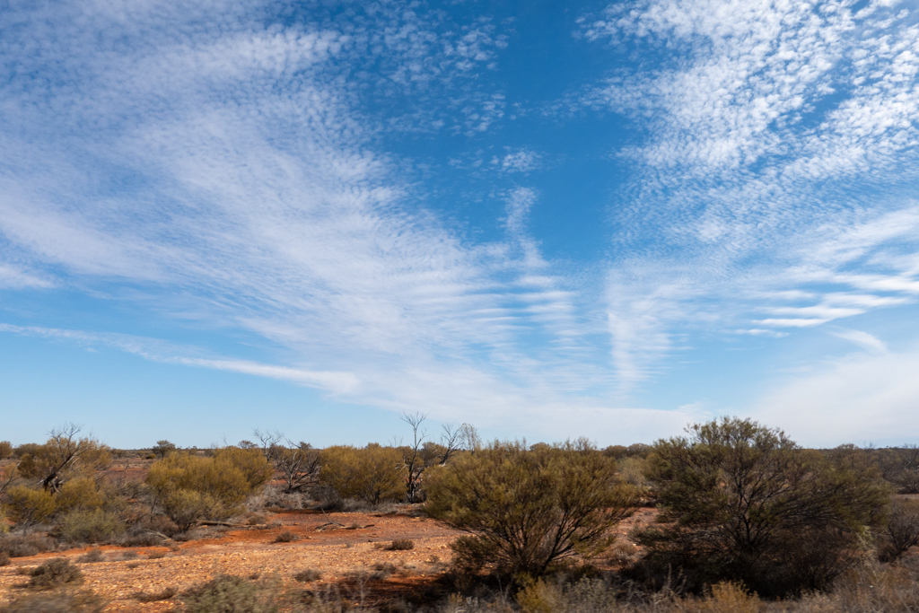 Hohe weisse Wolken am blauen Himmel über den Weiten des Outbacks