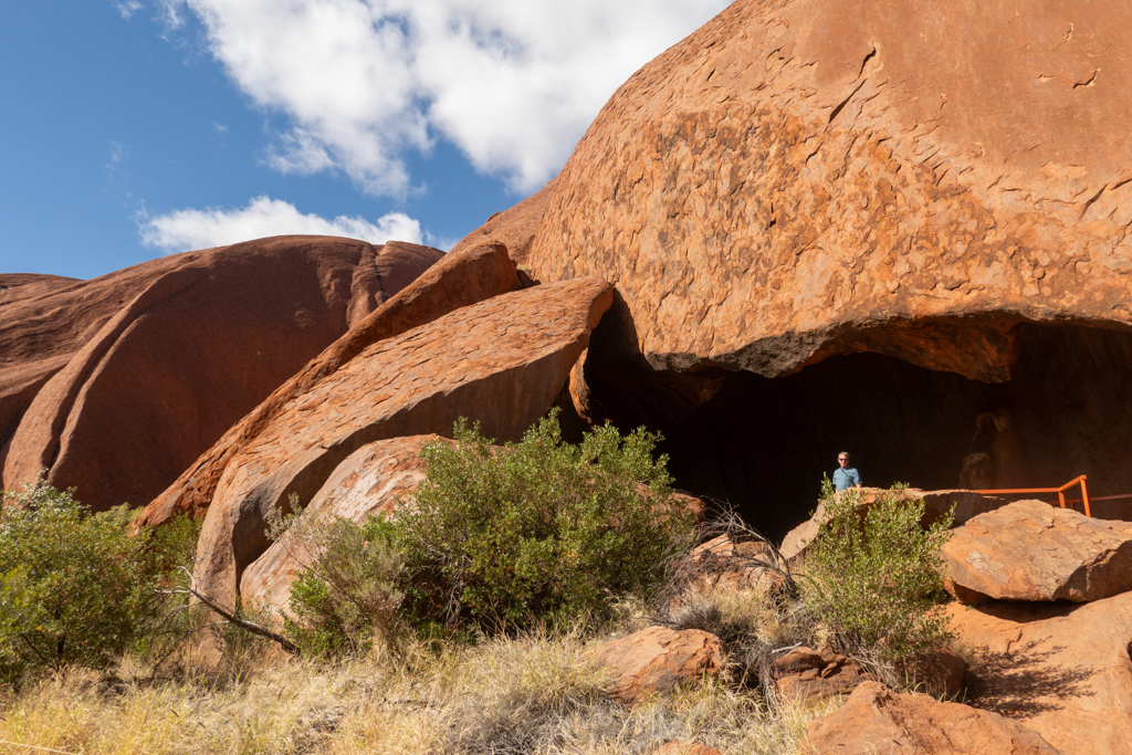 Jo posiert an einer der Höhlen am Boden des Uluru
