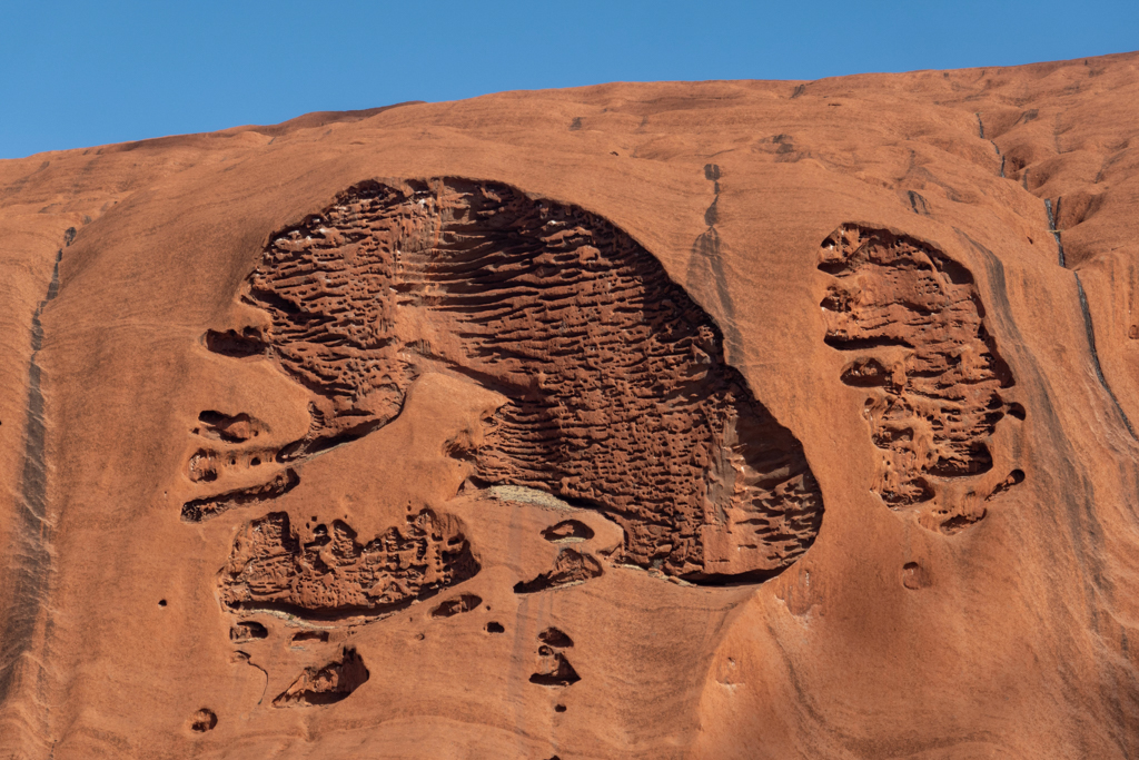 Es sieht wie ein übergrosser Fussabdruck aus was aus der Oberfläche des Uluru herausgebrochen ist