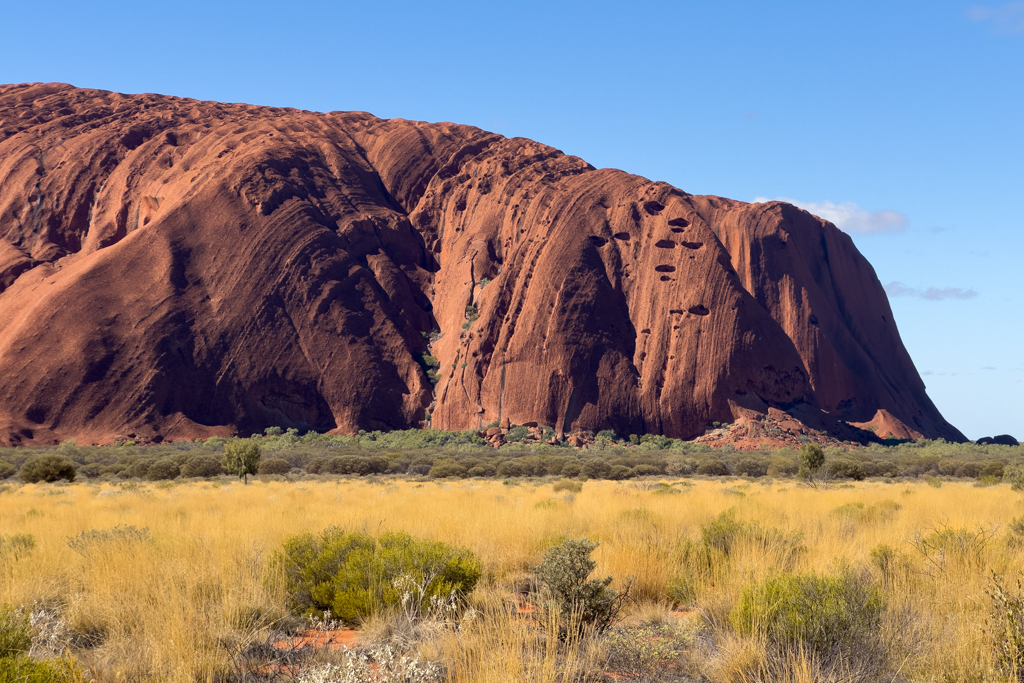 Im tiefen Sonnenlicht sind die Riefen und das zerklüftete Gestein des Uluru deutlich sichtbar