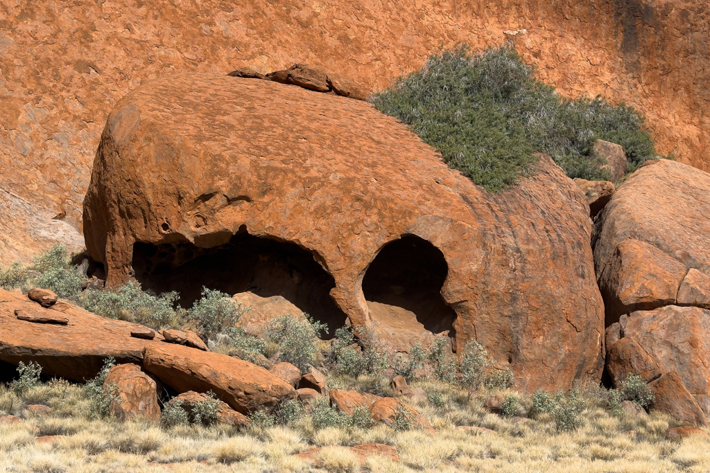 Überall um Uluru herum liegen abgebrochene Felststücke aus denen selber Stücke herausgebrochen sind