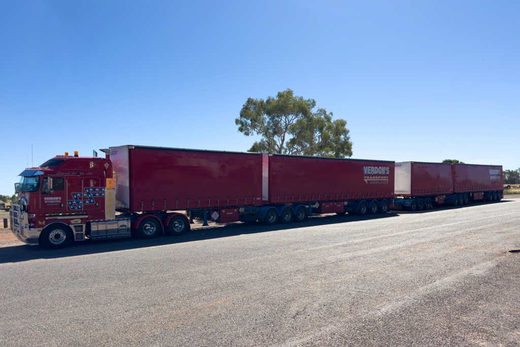 Ein grosser 4-teiliger Road Train macht beim Devils Marbles Roadhouse Station