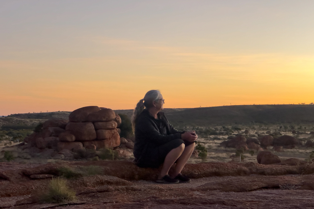 Ma geniesst den Sonnenuntergang bei den Devils Marbles