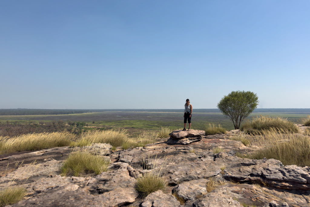 Ma posiert erfreut oben auf dem Ubirr. Hinter ihr die unterschiedliche Landschaft
