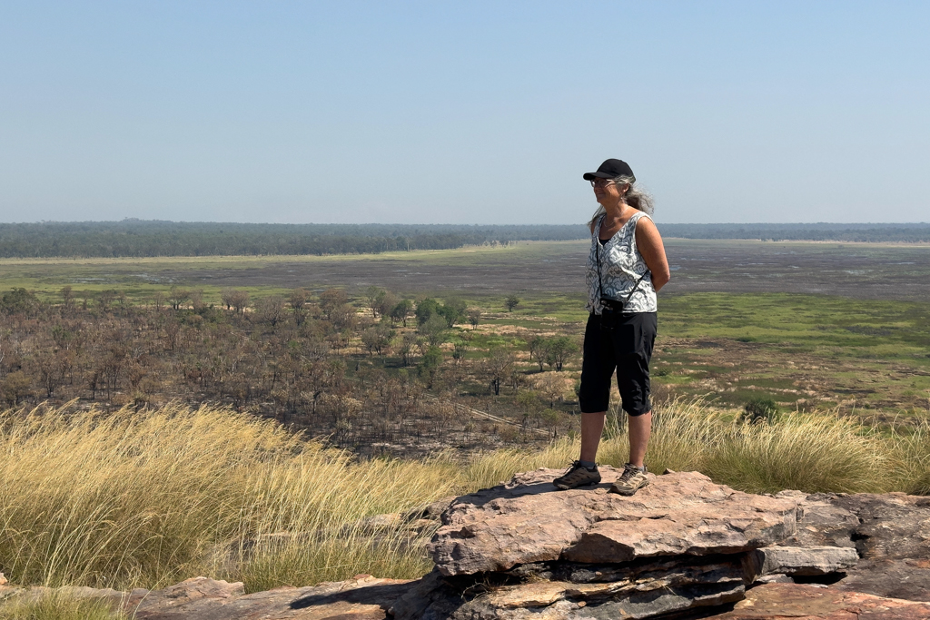 Ma posiert erfreut oben auf dem Ubirr. Hinter ihr die unterschiedliche Landschaft