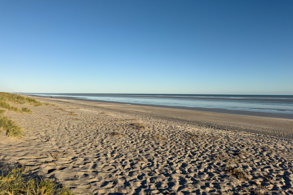 Ein breiter leerer Strand am Morgen kurz nach Sonnenaufgang bei Ebbe