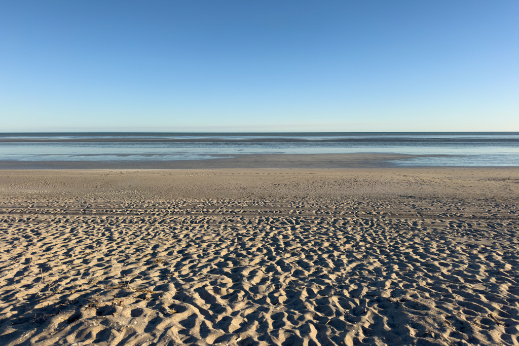 Ein breiter leerer Strand am Morgen kurz nach Sonnenaufgang bei Ebbe