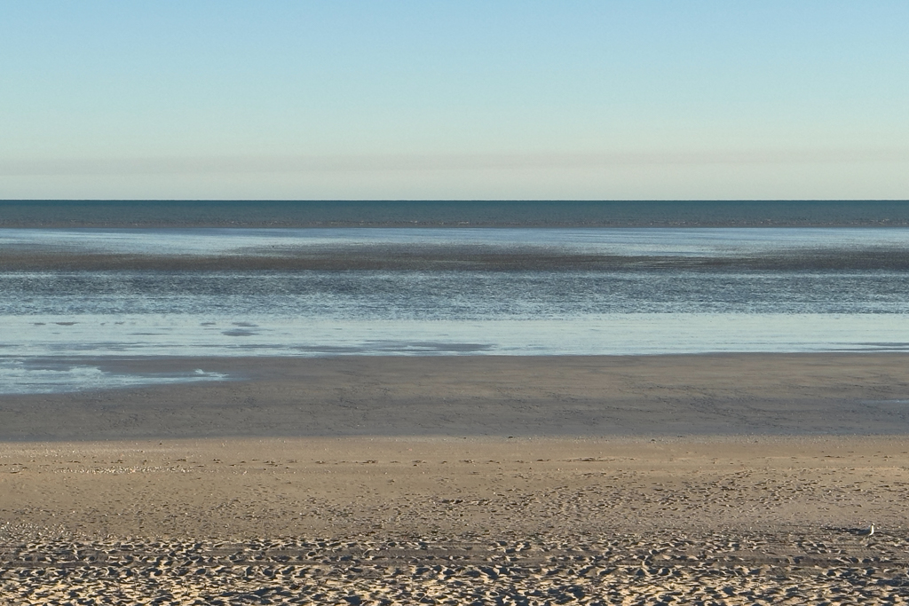 Ein breiter leerer Strand am Morgen kurz nach Sonnenaufgang bei Ebbe