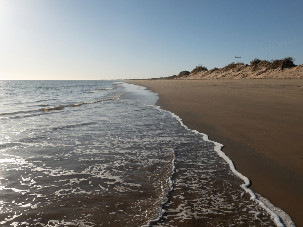 Langsam geht die Sonne an der menschenleeren Town Beach unter.