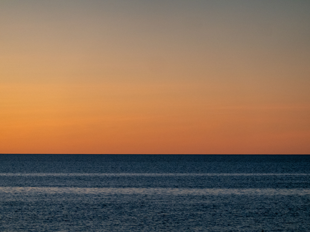 In einem dunklen Gelb erscheint der Abendhimmel nach dem Sonnenuntergang