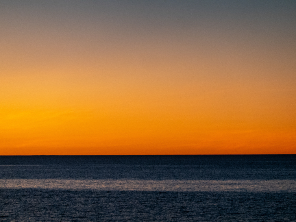 In einem dunklen Gelb erscheint der Abendhimmel nach dem Sonnenuntergang