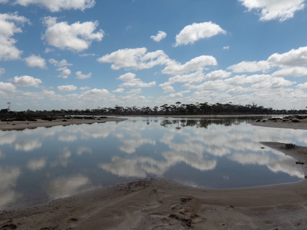 Der Himmel spiegelt sich im flachen Wasser eines Salzsees