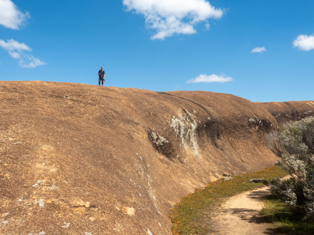 Jo posiert am Rand einer kleineren Welle oben auf dem Wave Rock Felsen