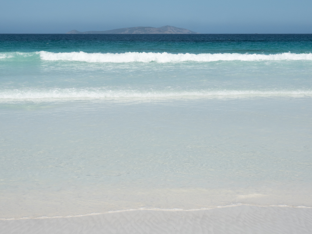 Farbenspiel: Weisser Strand, das klare blaue Meer und der weite Himmel