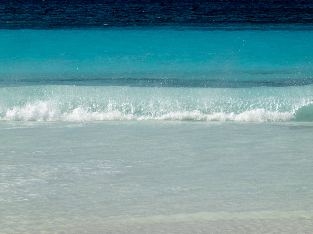 Farbenspiel mit weissem Strand und dem klaren, türkis blauen Meer