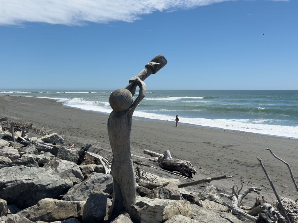 Holzkunst an der Küste von Hokitika mit Ma im Hintergrund an der Beach