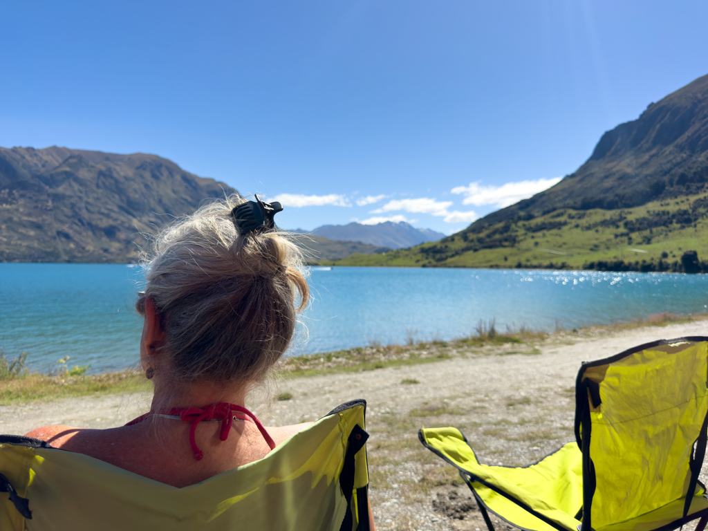 Ma geniesst den Lake Hāwea und die herrliche Aussicht auf die Berge