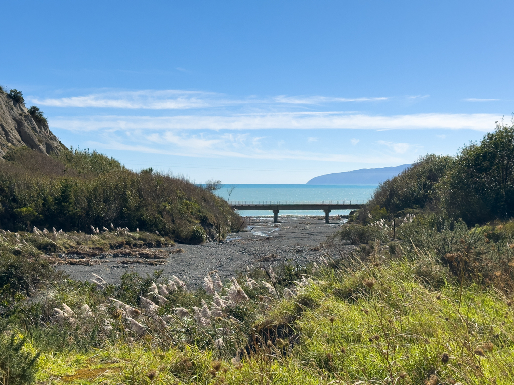 Ausgetrocknetes Flussbett des Putangirua Streams, dahinter das Meer